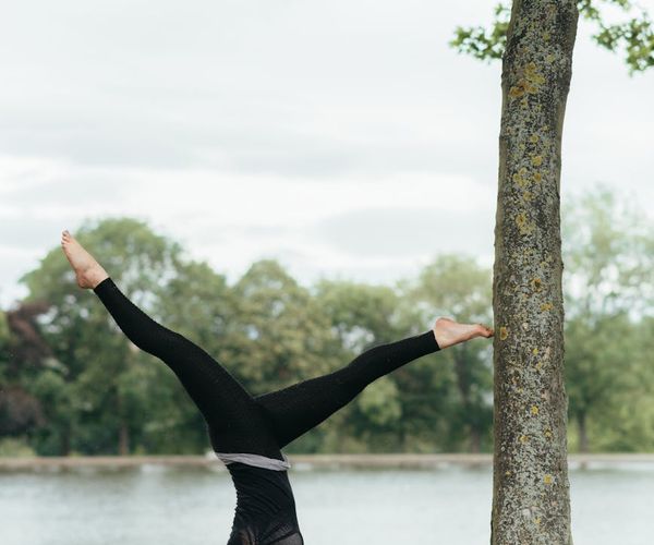 Woman performing a challenging yoga balance pose, showing strength.